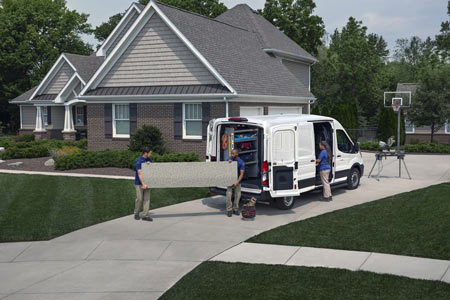 White Ford Transit cargo van being unloaded by workers