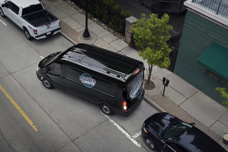 Black Ford Transit cargo van parking on street
